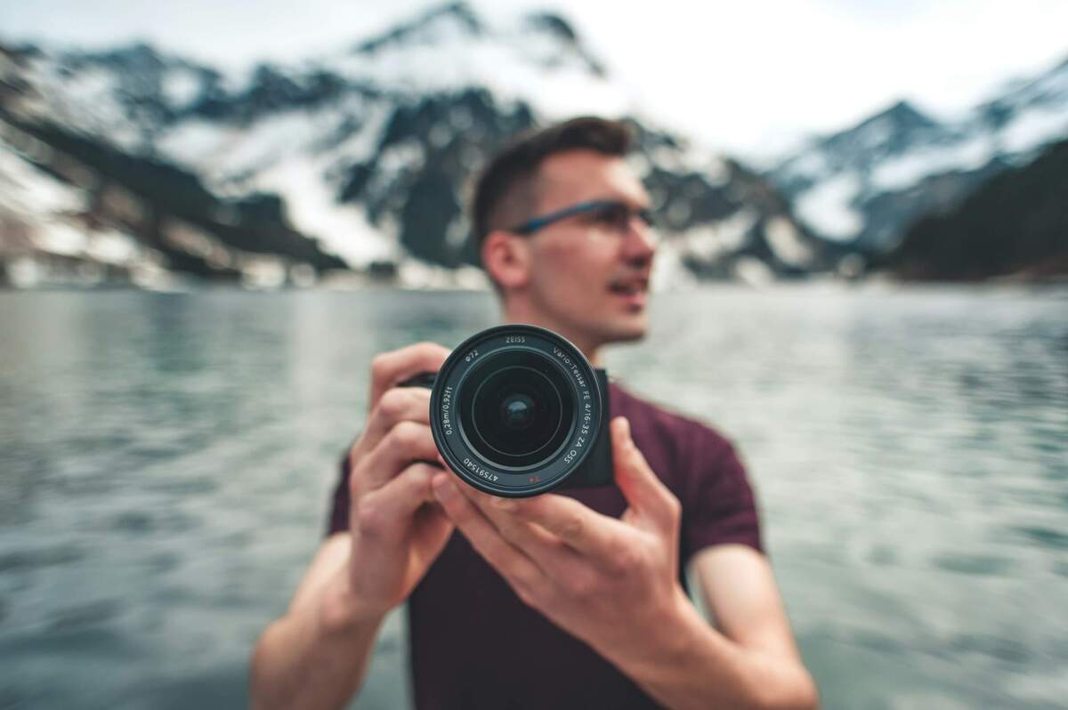 Fotografo al lago tra le montagne