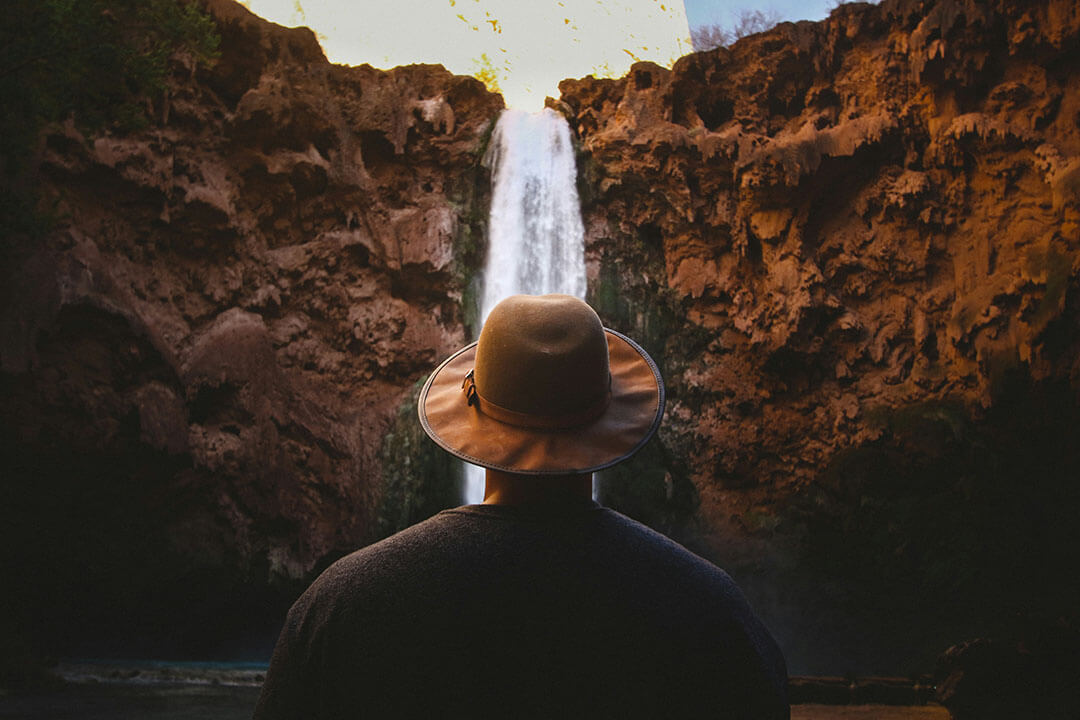 Uomo che guarda una cascata